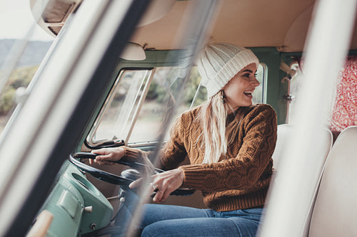 Beautiful woman on road trip driving a van