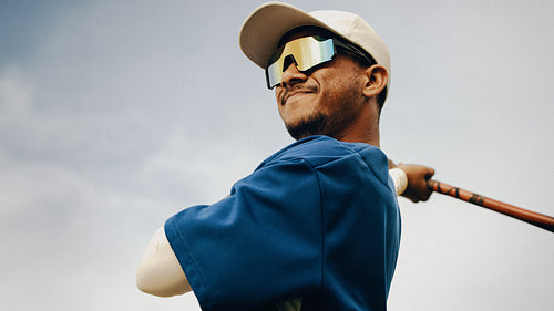 Confident baseball player in blue attire preparing to swing the bat