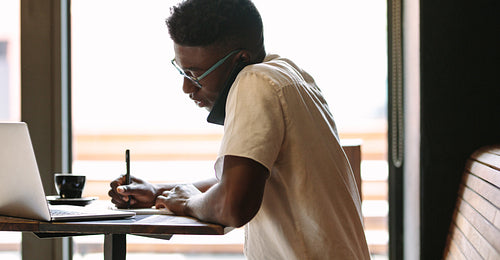 Freelancer doing his work sitting at a coffee shop