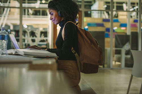 Woman student at library using laptop