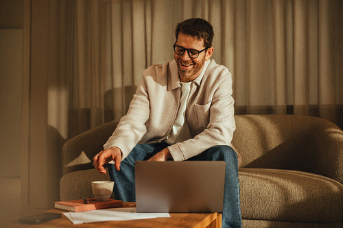 Businessman enjoys working on a laptop in a warm office setting