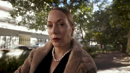 Beautiful rich woman standing in the park