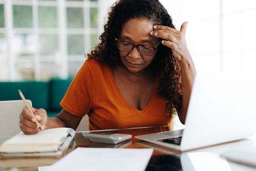 Retired woman getting stressed while doing her personal budget