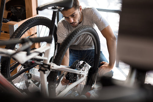 Mechanic assembling a bicycle in workshop