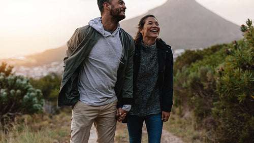Smiling couple walk through country trail