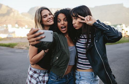 Happy friends making selfie with smart phone