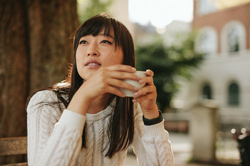 Beautiful young chinese woman having coffee at cafe