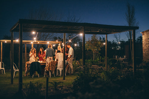 Group of friends having dinner party outdoors