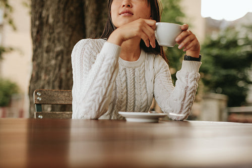 Young woman holding a cup of coffee at cafe