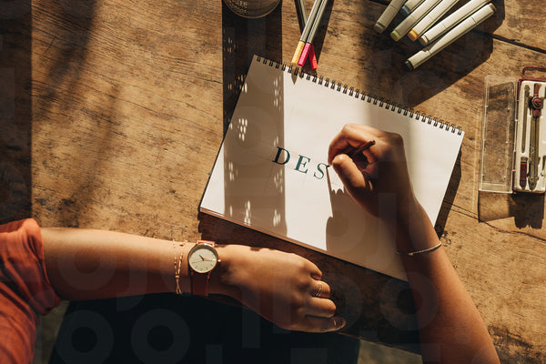 Female designer drawing on a note pad