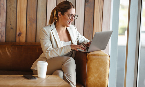 Business woman using a laptop while working in a cafe