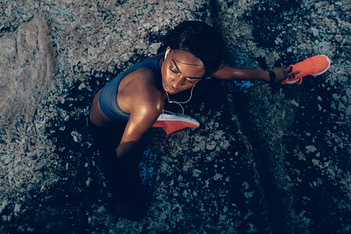 Fit woman sitting over rocks after workout