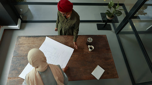 Female architects collaborating on a floor plan design in an office