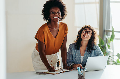 Happy female colleagues collaborating in a bright office setting