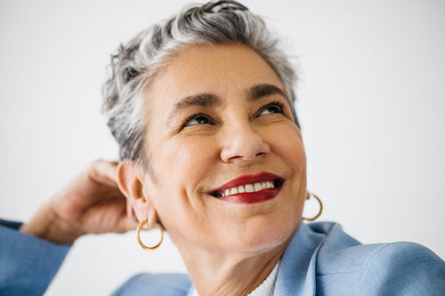 Successful senior business woman looking thoughtful in an office