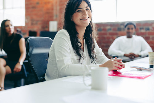 Creative businesswoman smiling while sitting in a modern office