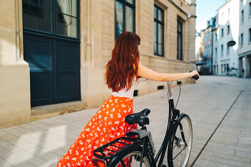 Female traveller exploring a city with a bicycle