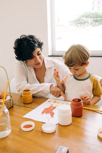 Mother teaching her son to paint