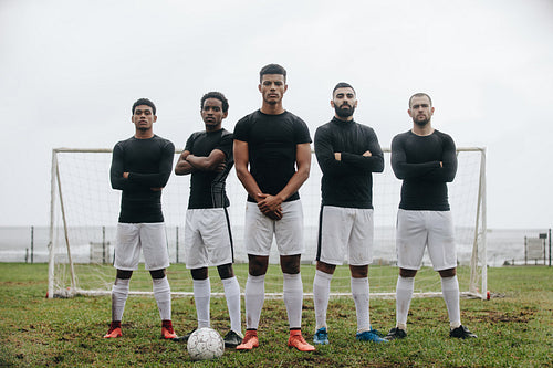 Football players standing on a soccer field in front of goalpost