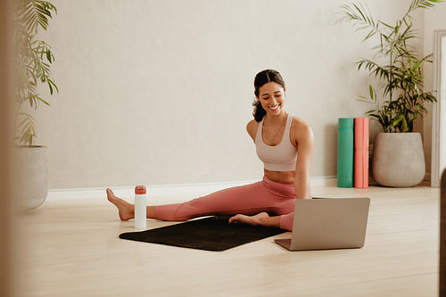 Woman attending online fitness class for exercising at home