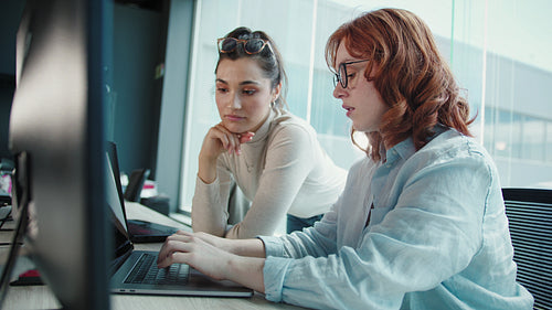 Business women having a discussion and working on a code