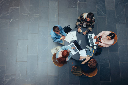 Young people studying together at college library