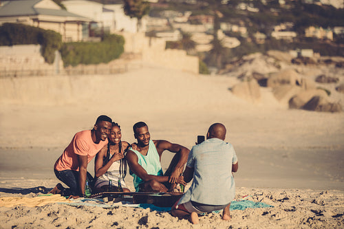 Group of friends on the beach taking pictures