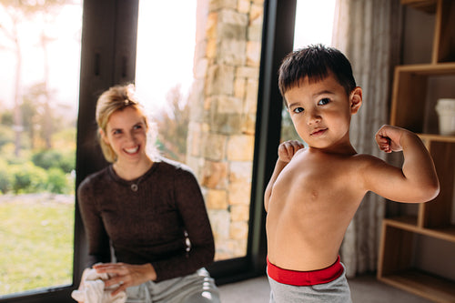 Little strong boy showing his biceps.