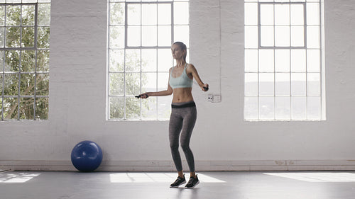 Woman exercising with jumping ropes at fitness studio