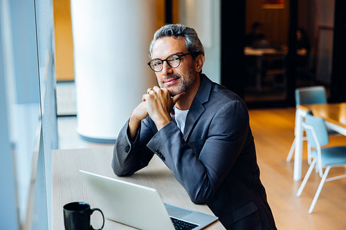 Professional man working on a laptop in a bright open office space
