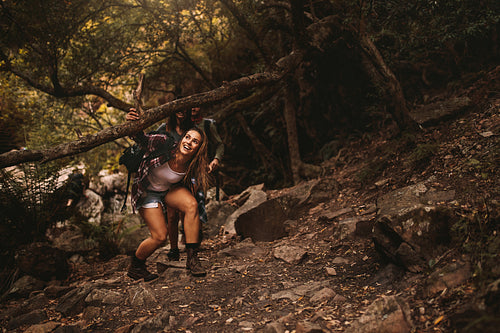 Friends hiking up a extreme terrain in forest