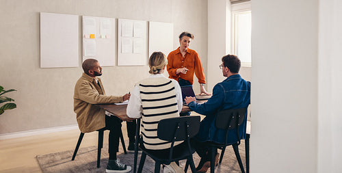 Mature team leader having a discussion with her colleagues in an office