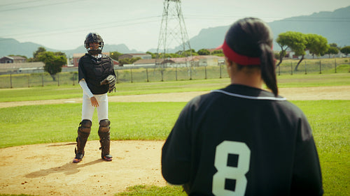 Baseball pitcher and catcher practice on field