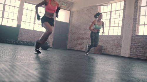 Two women doing Speed and agility running drill in gym