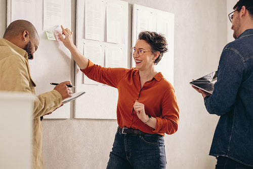 Cheerful businesswoman laughing while having a discussion with her team