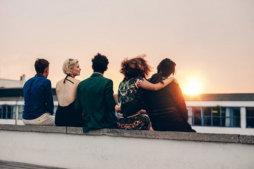 Friends relaxing on terrace in evening
