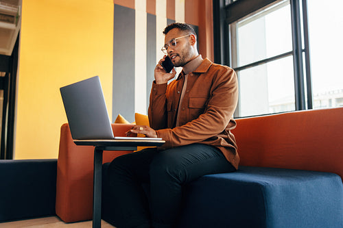 Young businessman taking a phone call in a co-working space