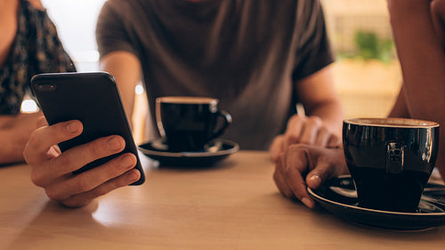 Young people at coffee shop with phone