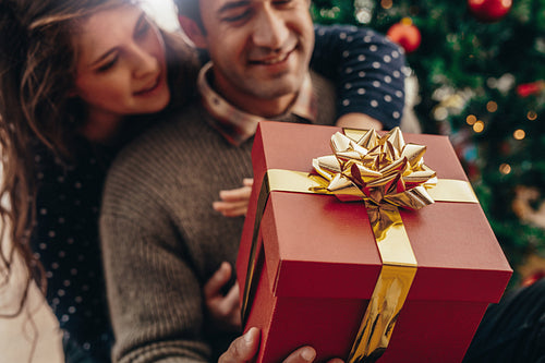 Young couple with a Christmas gift box.