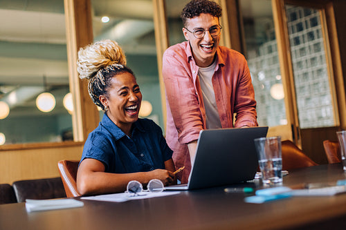 Colleagues enjoying a light-hearted moment while working together in the office
