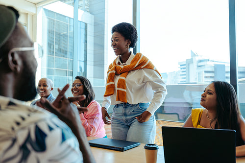 African female business professional leading a casual meeting in a modern office