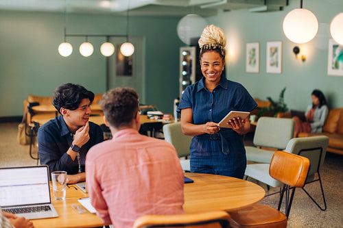 A cheerful professional team discussing ideas at a casual business meeting