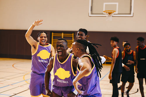 Basketball team celebrates victory on the court during a match