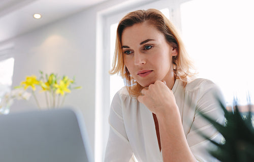 Young female florist using laptop