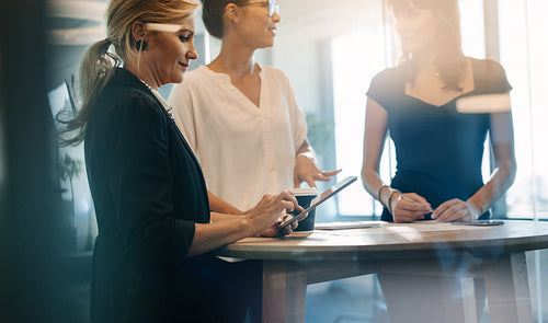 Three female colleagues having a standing meeting 
