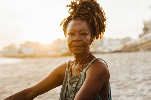 Mature African American woman enjoying serene moment by the sea.