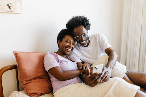 Quality time: Happy couple enjoying a video chat in their bedroom
