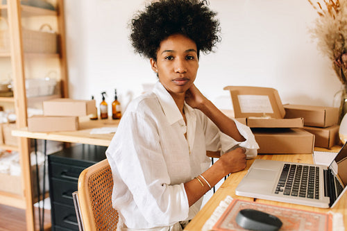 Thoughtful entrepreneur sitting in jewelry workshop