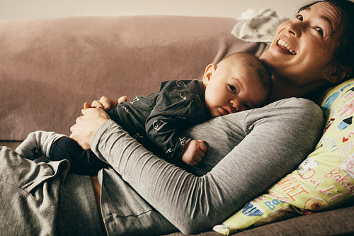 Close up of a mother lying on couch with her baby