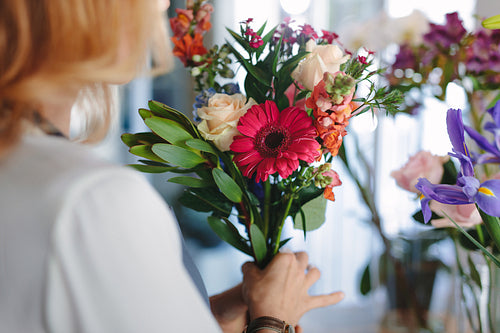 Mixed flowers in hands on female florist
